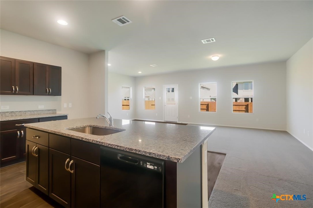 2428 Ambling Trail Georgetown, TX 78628 - Photo 5 of 33 a kitchen with stainless steel appliances granite countertop a sink a stove and a refrigerator