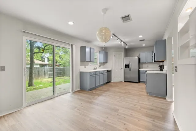 a large kitchen with a lot of cabinets and stainless steel appliances