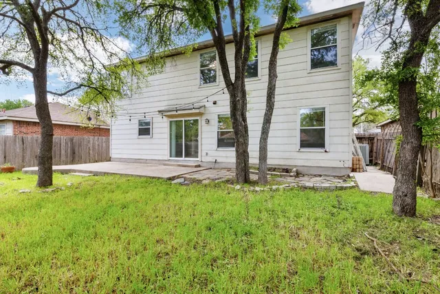 a view of a house with backyard and a tree