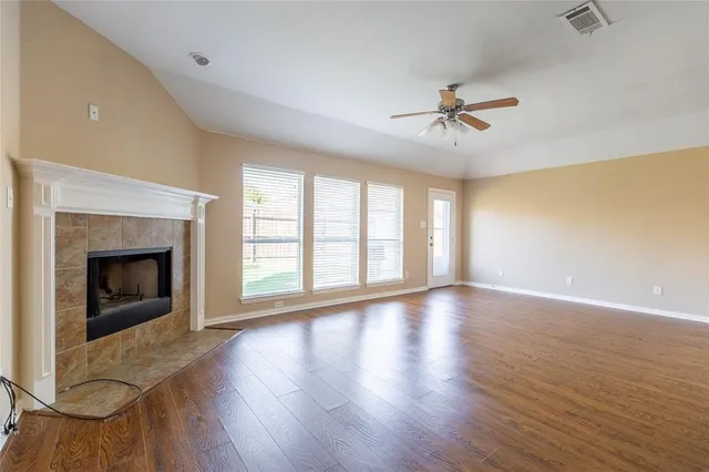 an empty room with windows fireplace and a sink