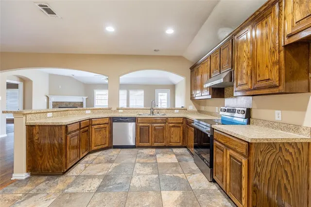 a large kitchen with stainless steel appliances lots of counter top space
