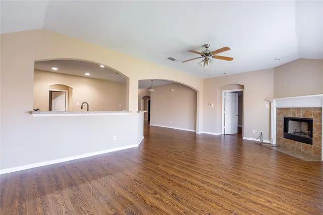 a view of an empty room with window and wooden floor