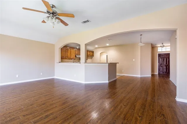 a view of a kitchen with wooden floor and a ceiling fan