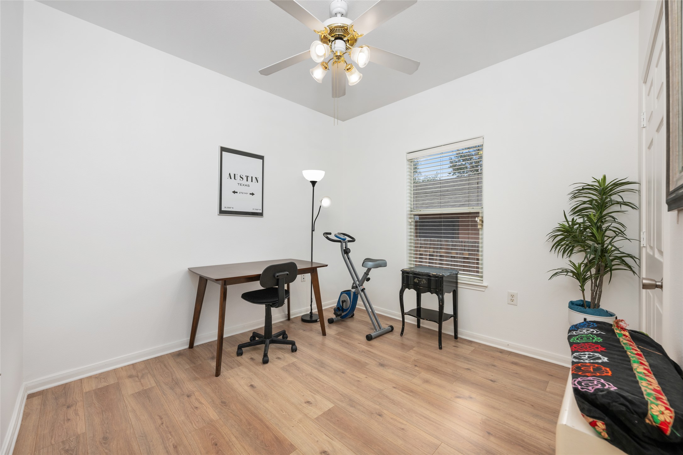 5613 Signal Point Austin, TX 78724 - Photo 8 of 21 Bright room featuring wood-finish flooring, white walls, and a ceiling fan with integrated lighting