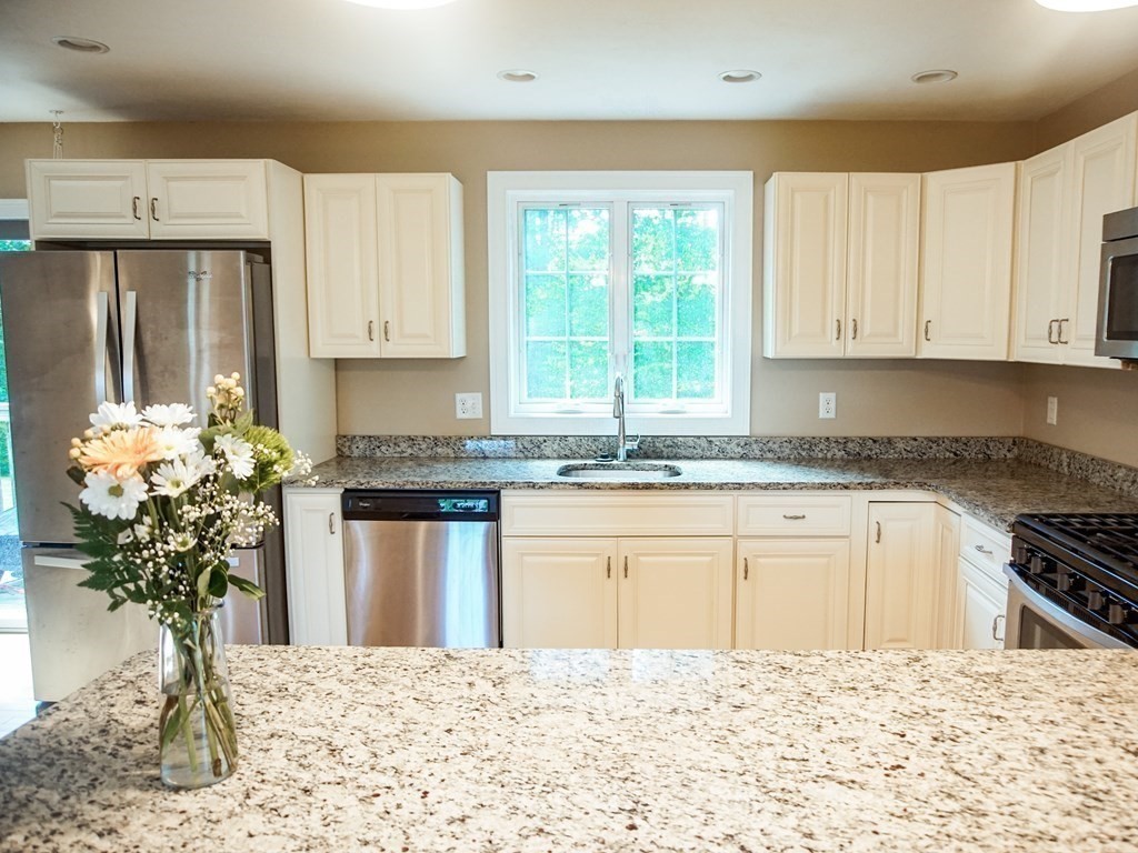 206 Haymeadow Lane Ayer, MA 01432 - Photo 11 of 41 a kitchen with stainless steel appliances granite countertop a stove a sink and a white cabinets