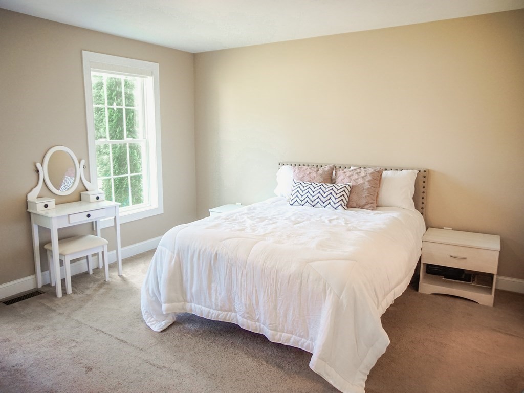 206 Haymeadow Lane Ayer, MA 01432 - Photo 14 of 41 a bed sitting in a bedroom next to a window