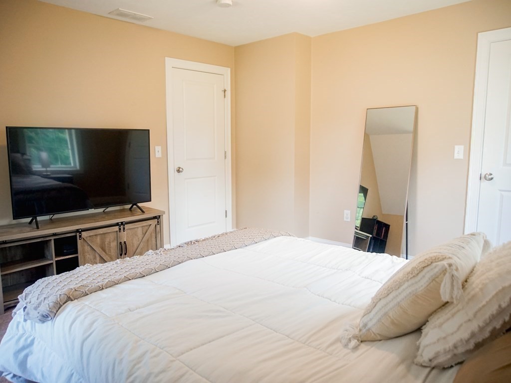206 Haymeadow Lane Ayer, MA 01432 - Photo 34 of 41 a bedroom with a bed and a flat screen tv