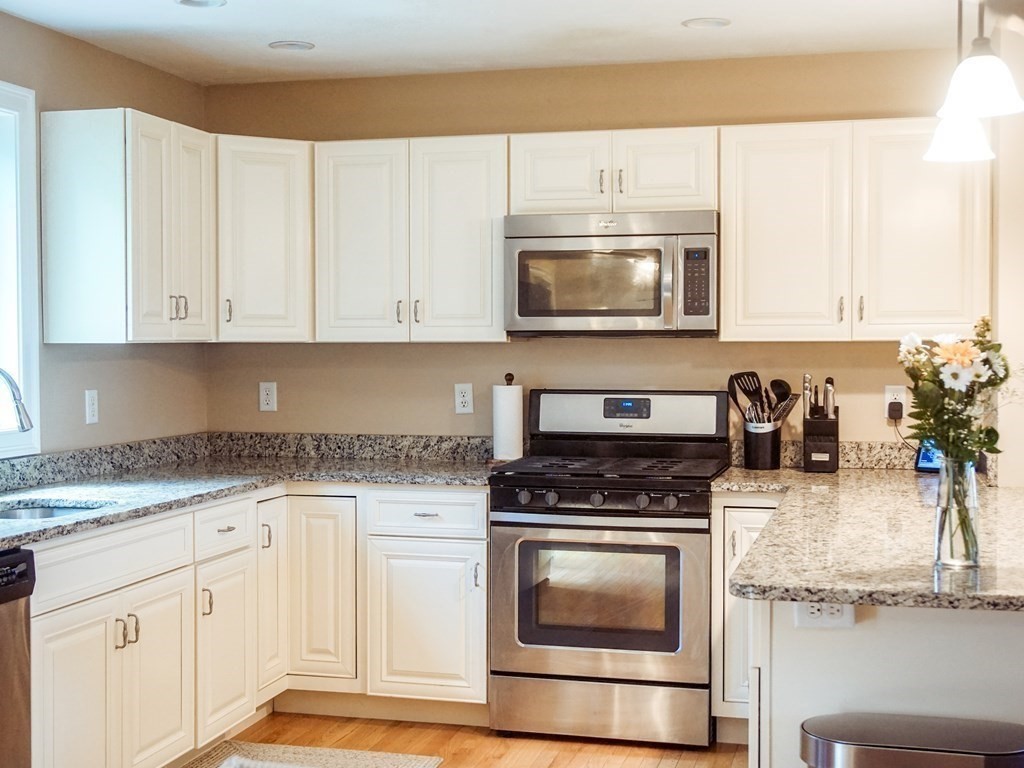206 Haymeadow Lane Ayer, MA 01432 - Photo 10 of 41 a kitchen with granite countertop a stove a sink and a microwave