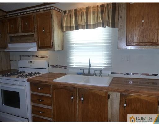 22-22 Longfellow Road North Brunswick, NJ 08902 - Photo 3 of 9 a kitchen with granite countertop a sink a stove and cabinets