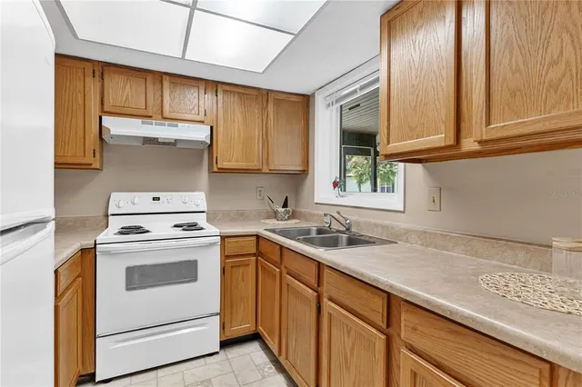 a kitchen with granite countertop cabinets stainless steel appliances a sink and window