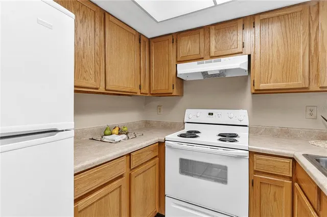a kitchen with granite countertop cabinets stainless steel appliances and a sink