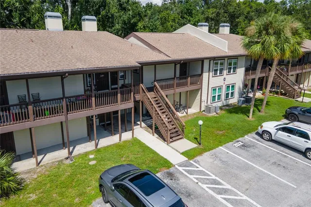 a view of a house with a yard deck and a large tree