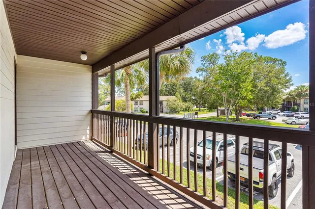 a view of a porch with wooden floor in front of a house