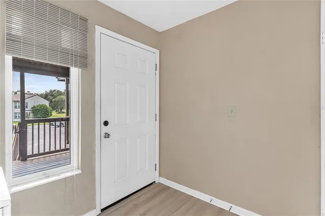 a view of a hallway with wooden floor and entryway