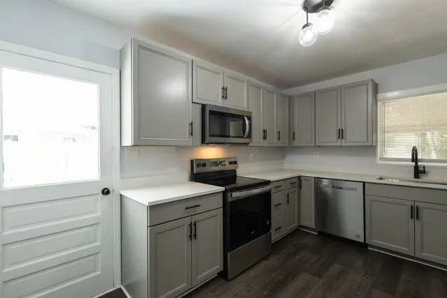 a kitchen with a sink stove and microwave