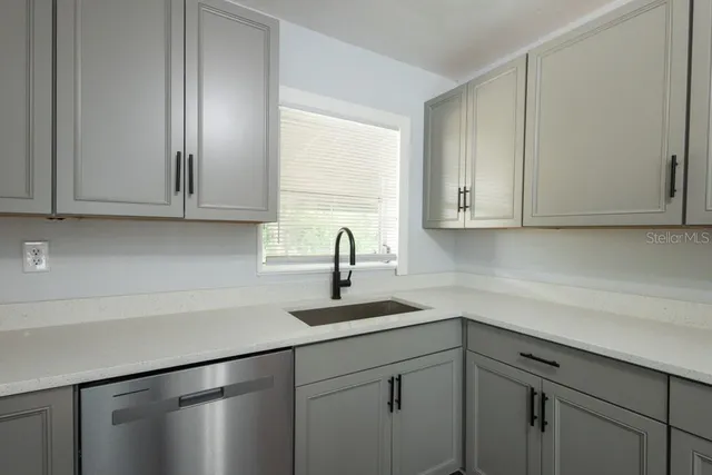 a kitchen with stainless steel appliances granite countertop white cabinets sink and dishwasher