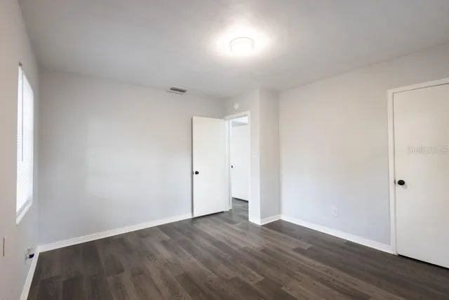 a view of an empty room with wooden floor