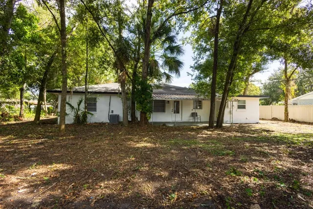 a front view of a house with a garden and trees