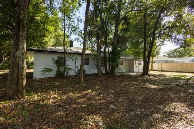 a view of a house with backyard and a tree
