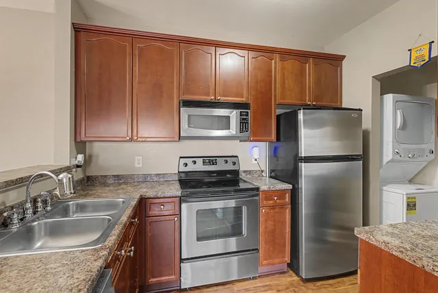 a kitchen with granite countertop a refrigerator stove and oven