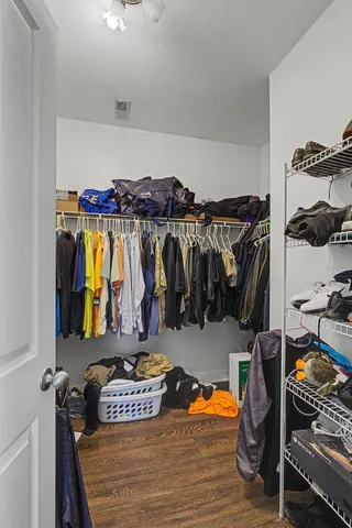 a view of walk in closet with clothes and shoes