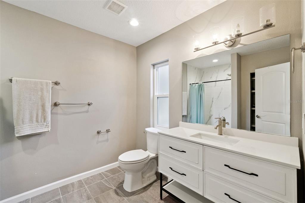 1304 Perkins Road Orlando, FL 32809 - Photo 15 of 22 a bathroom with a double vanity sink toilet and mirror