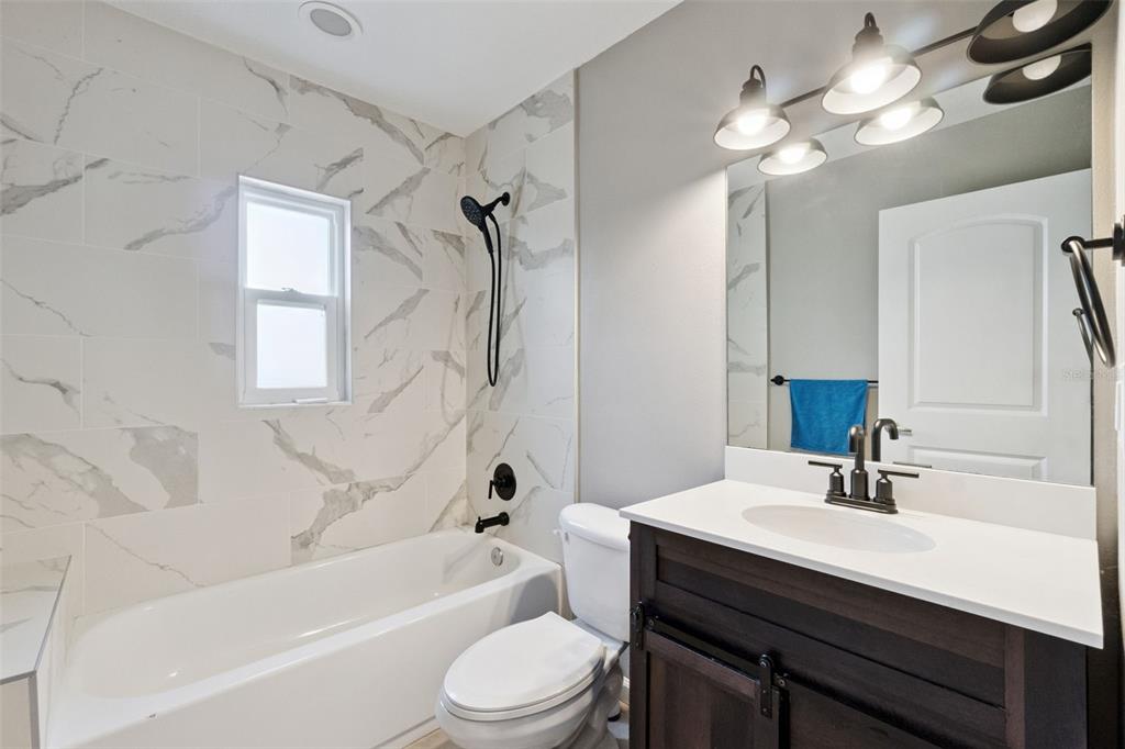 1304 Perkins Road Orlando, FL 32809 - Photo 16 of 22 a bathroom with a sink a toilet a mirror and shower