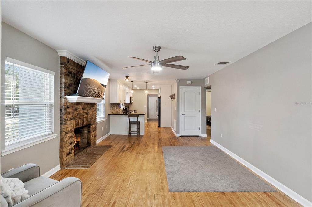 1304 Perkins Road Orlando, FL 32809 - Photo 7 of 22 a living room with fireplace furniture and a wooden floor