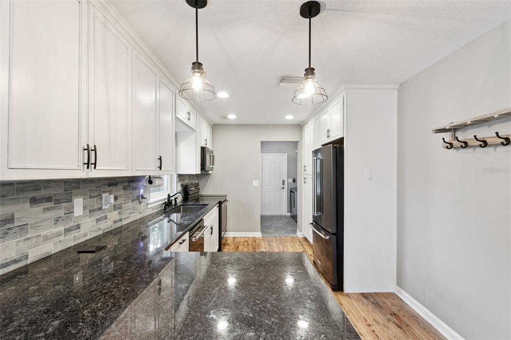1304 Perkins Road Orlando, FL 32809 - Photo 8 of 22 a kitchen with stainless steel appliances granite countertop a refrigerator a stove and a sink