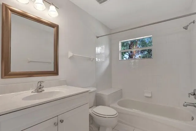 a bathroom with a granite countertop sink a toilet and a bathtub