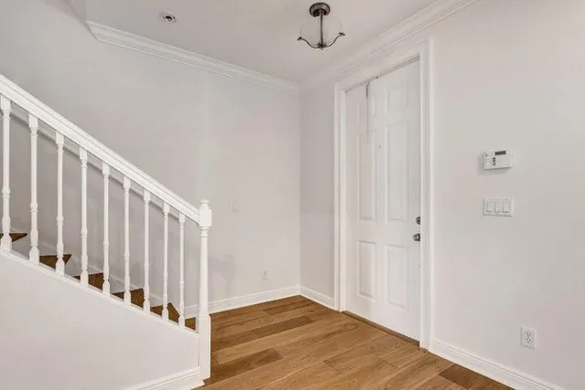 a view of a hallway with a white walls and stairs