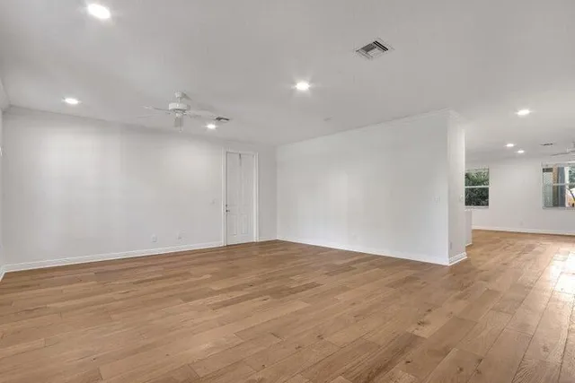 a view of an empty room with wooden floor