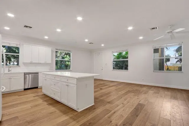 a large kitchen with stainless steel appliances granite countertop a large counter top and a wooden floors
