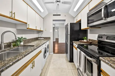 a kitchen with stainless steel appliances granite countertop a stove microwave and refrigerator