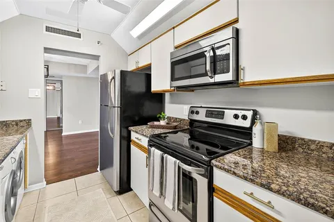 a kitchen with stainless steel appliances granite countertop a sink and a stove