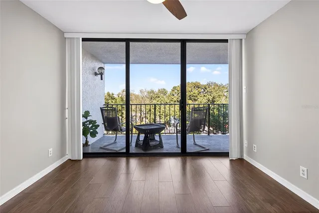 an empty room with wooden floor and ceiling fan