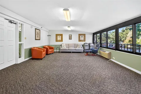 a view of a big room with windows and chandelier fan