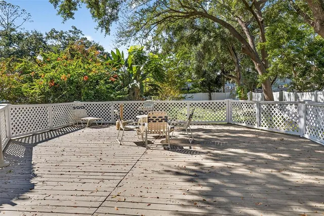 a view of a patio with table and chairs potted plants and a palm tree