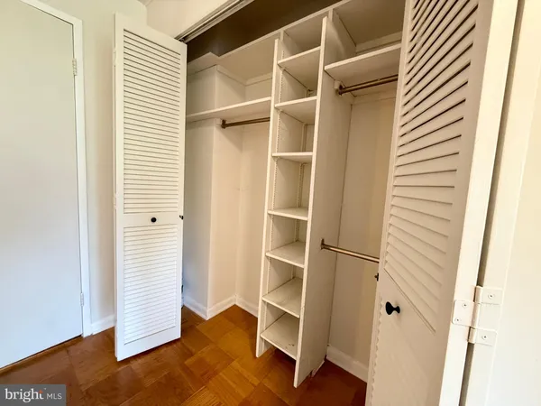 a view of walk in closet with empty racks
