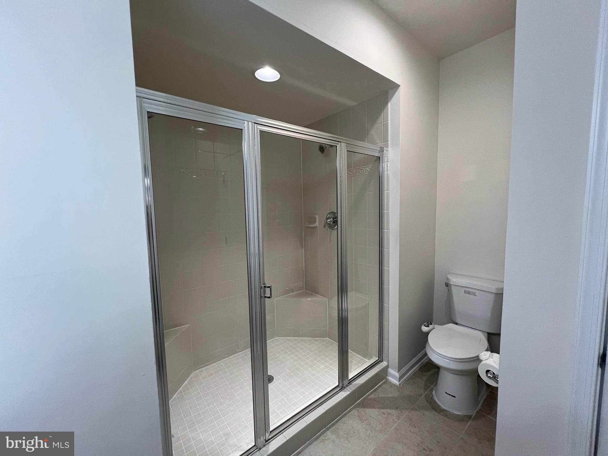5057 Small Gains Way Frederick, MD 21703 - Photo 11 of 22 a bathroom with a granite countertop toilet and a shower