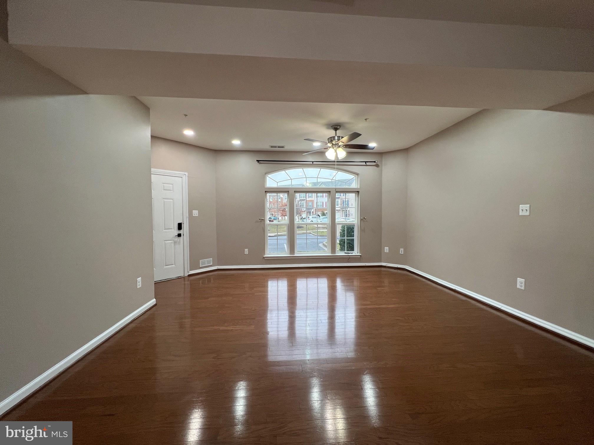 5057 Small Gains Way Frederick, MD 21703 - Photo 3 of 22 a view of an empty room with chandelier and wooden floor