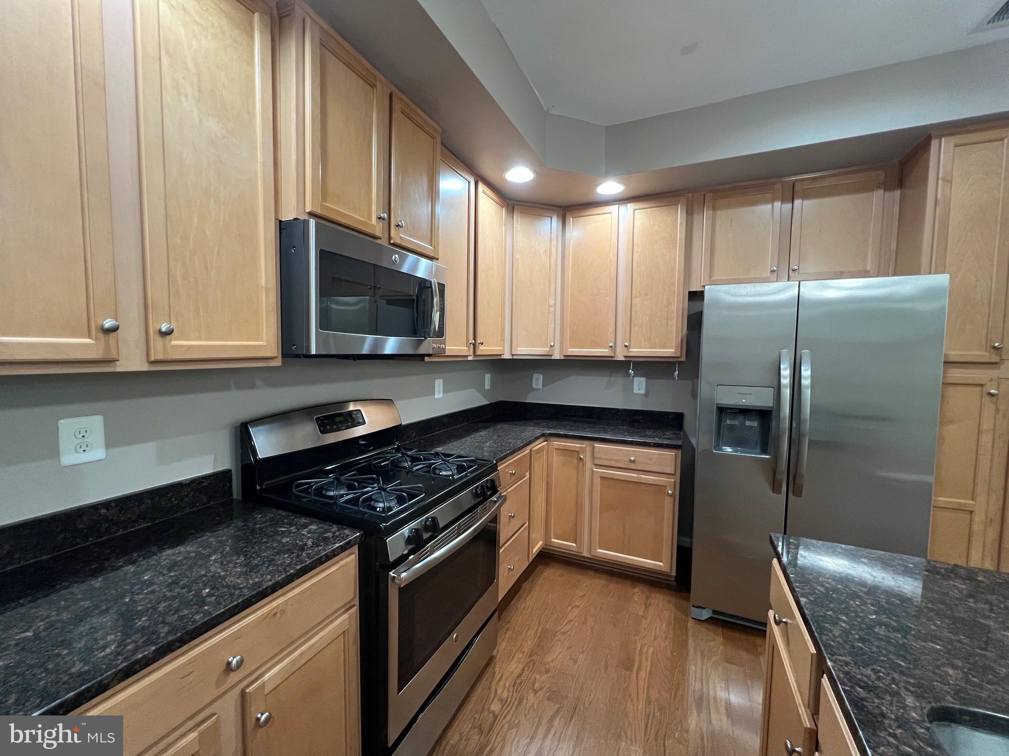 5057 Small Gains Way Frederick, MD 21703 - Photo 6 of 22 a kitchen with granite countertop a refrigerator stove and microwave