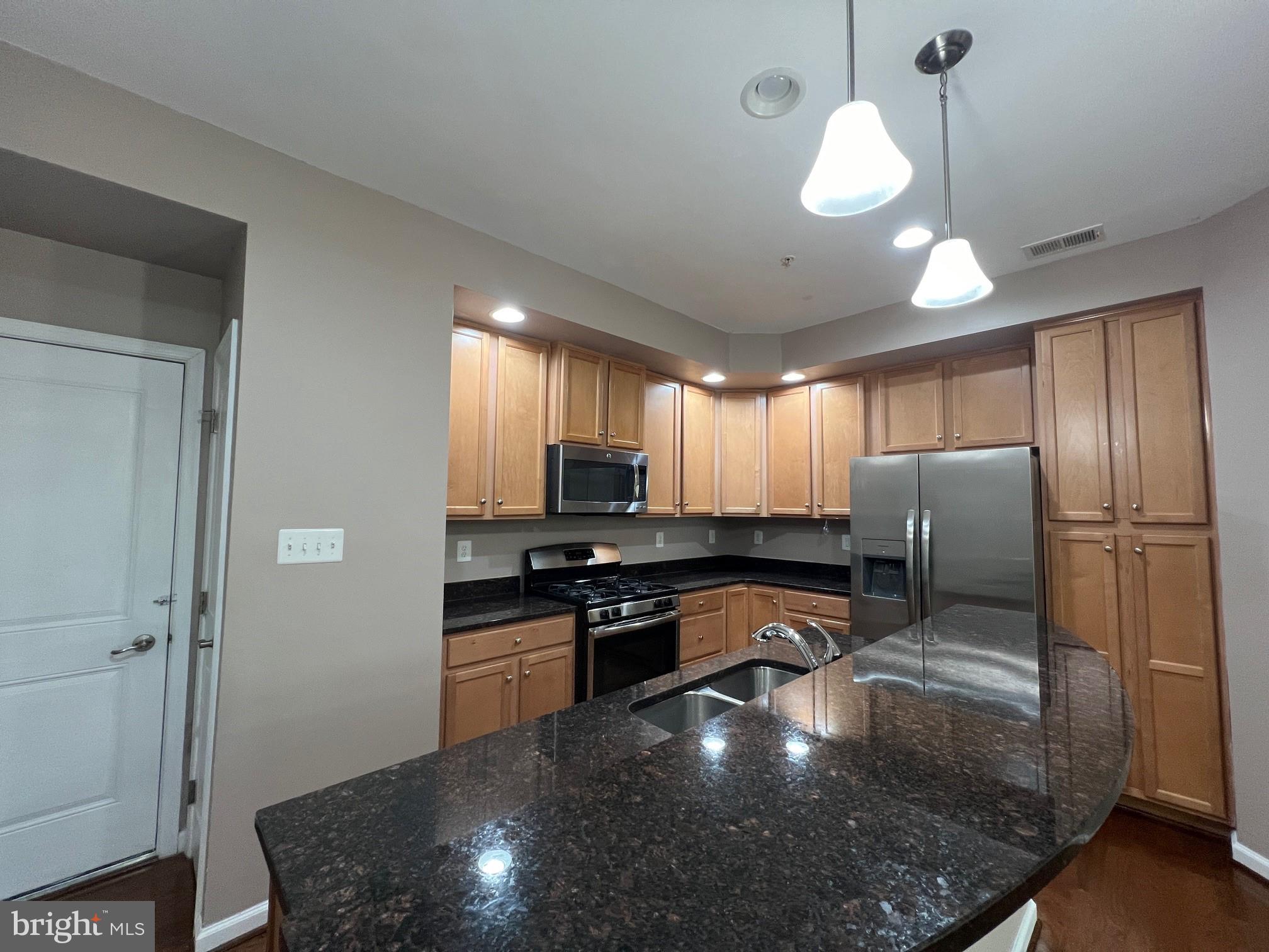5057 Small Gains Way Frederick, MD 21703 - Photo 7 of 22 a kitchen with stainless steel appliances granite countertop a stove sink and cabinets