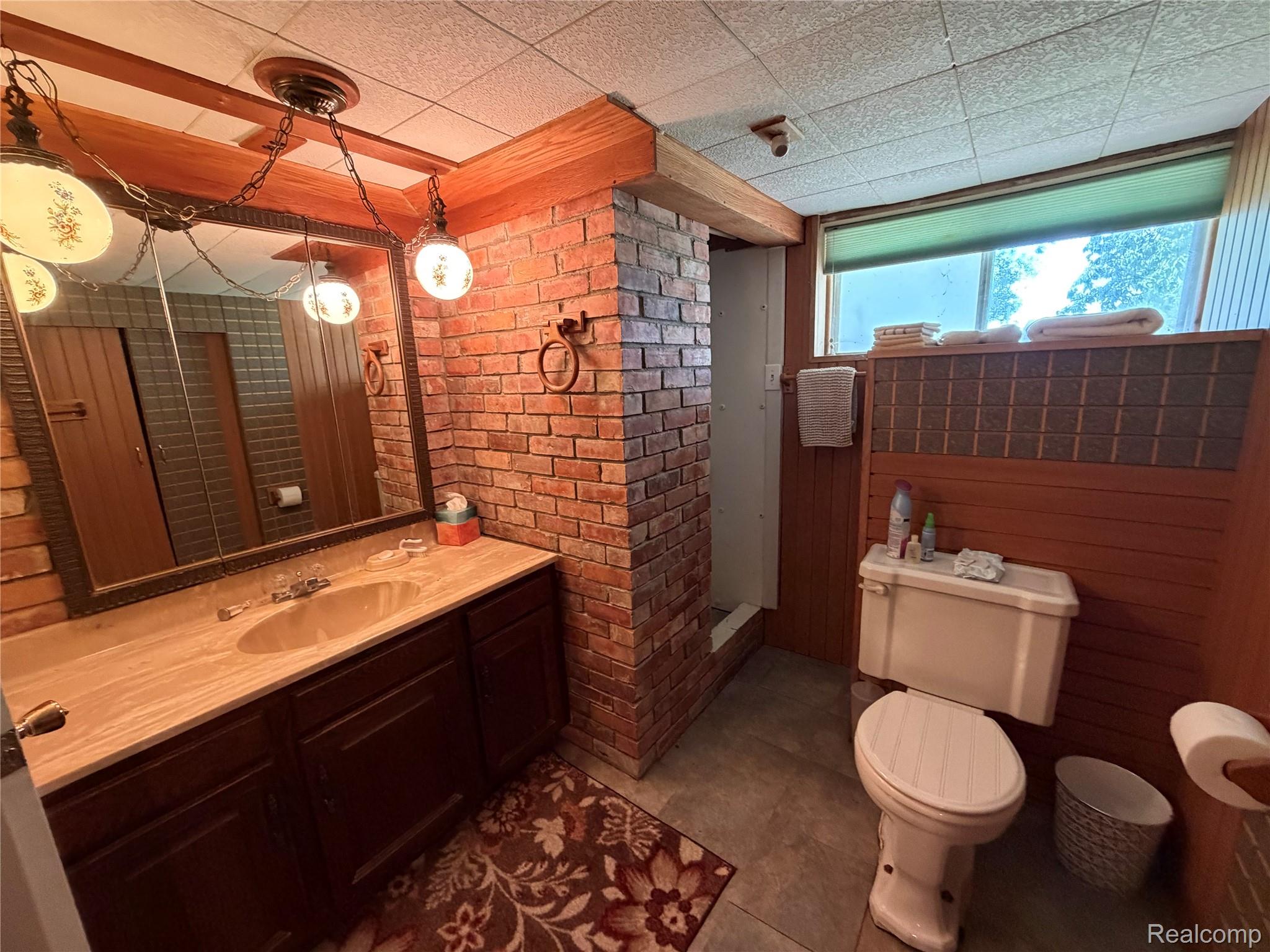 8886 East Burnside Road Brown City, MI 48416 - Photo 19 of 22 Bathroom featuring a wood-finish vanity with an integrated sink and a large framed mirror
