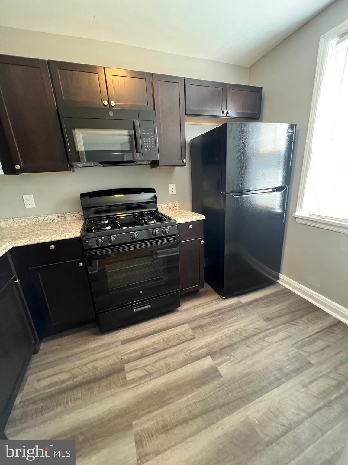 1128 Gleneagle Road Baltimore, MD 21239 - Photo 6 of 21 a kitchen with stainless steel appliances and wood cabinets