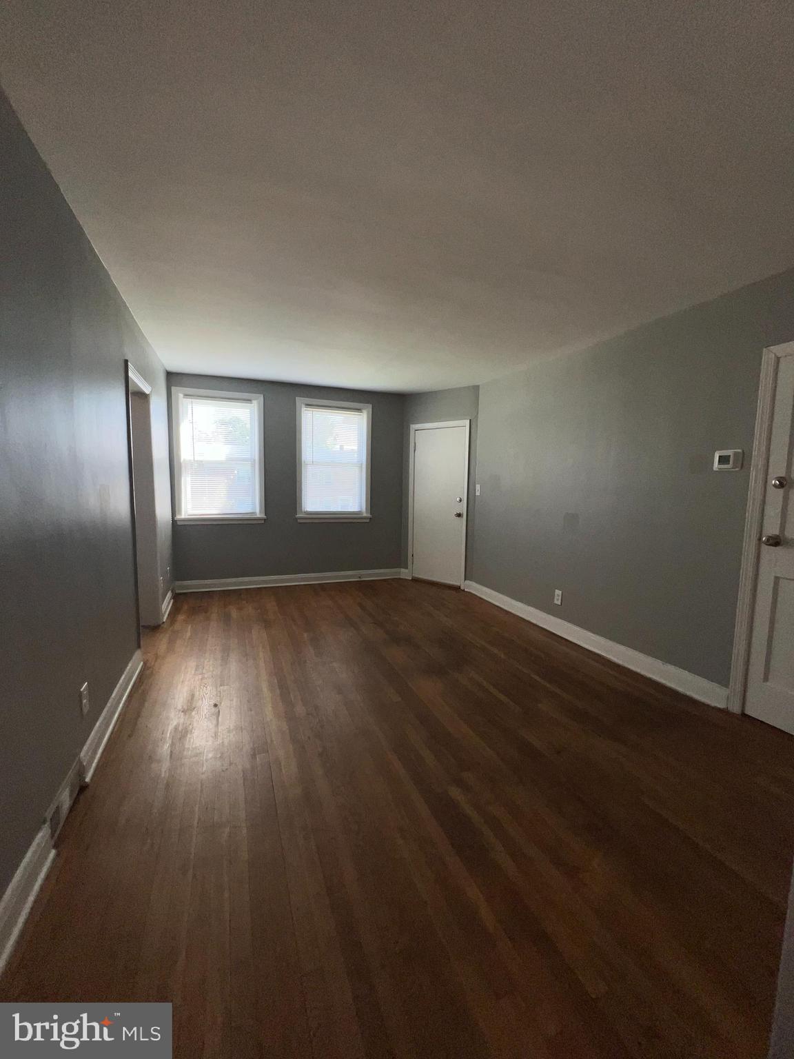 1128 Gleneagle Road Baltimore, MD 21239 - Photo 8 of 21 an empty room with wooden floor and windows