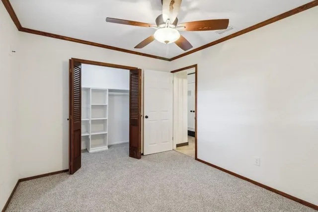 an empty room with a ceiling fan and entryway