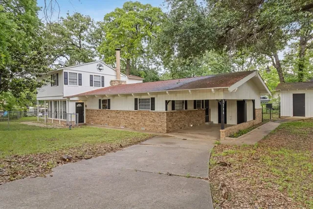 a front view of a house with a garden and yard
