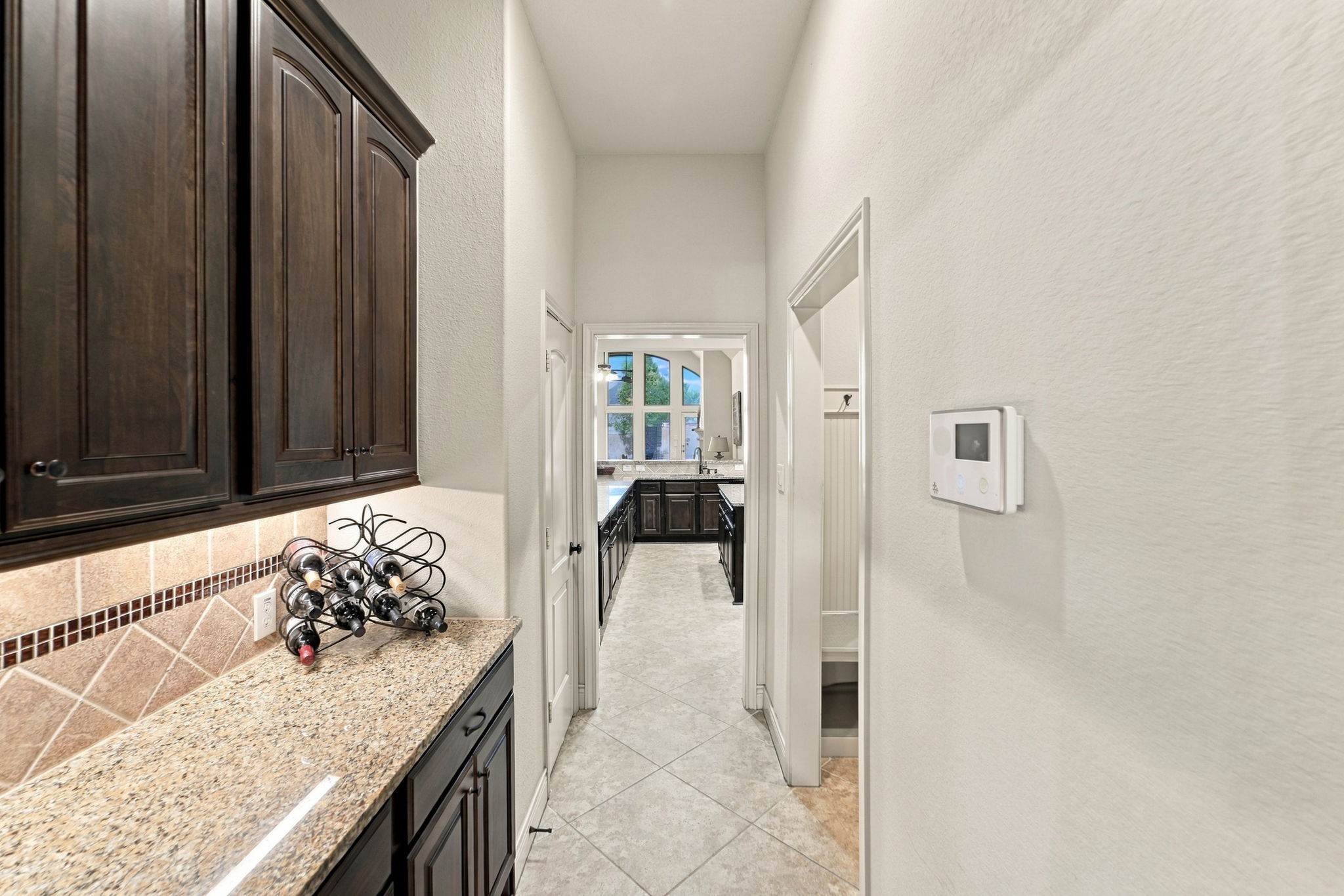 9818 Reston Ranch Court Cypress, TX 77433 - Photo 8 of 38 This butler's pantry offers extra prep and storage space with granite counters and rich cabinetry, creating a seamless connection between the dining room and kitchen.