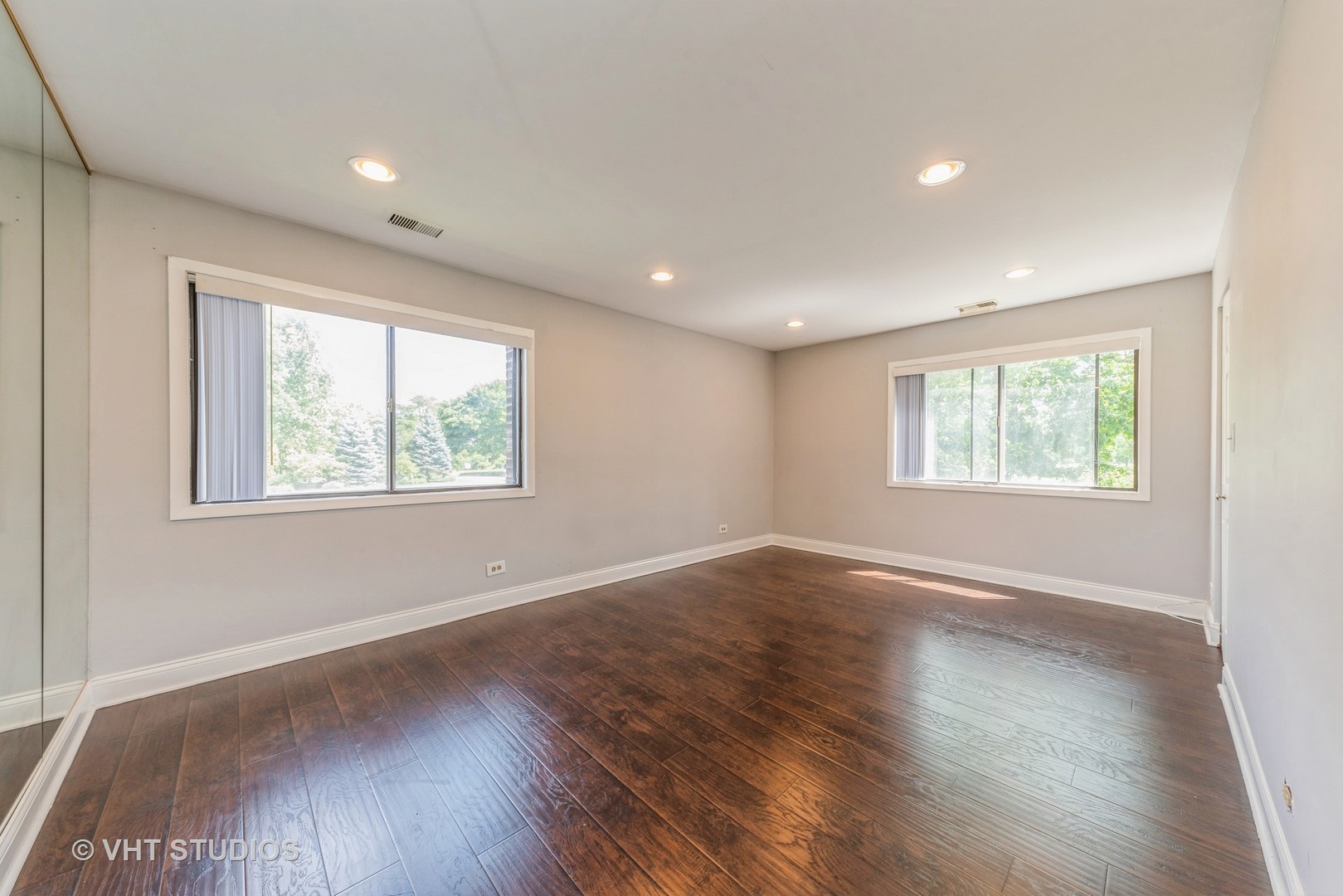 1400 North Elmhurst Road, Unit 219 Mount Prospect, IL 60056 - Photo 6 of 10 an empty room with wooden floor and windows